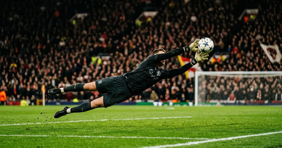Soccer goalkeeper at full stretch making a diving save under stadium floodlights