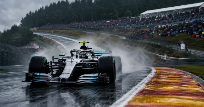 Silver Mercedes Formula 1 car racing through Eau Rouge at Spa-Francorchamps