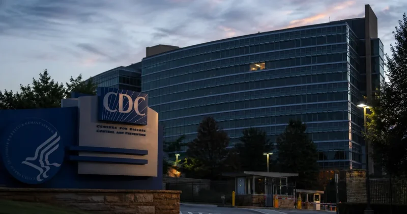 The CDC headquarters building in Atlanta at dusk, most windows dark, a single office lit