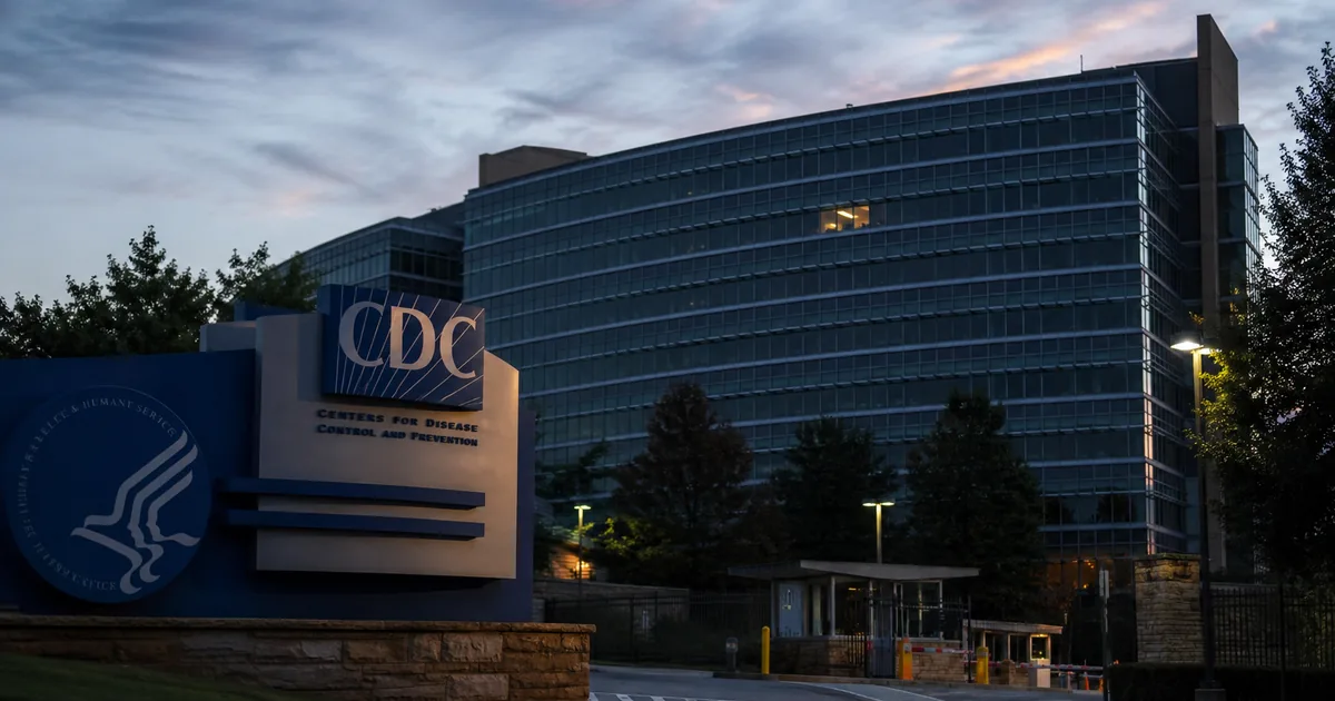 The CDC headquarters building in Atlanta at dusk, most windows dark, a single office lit