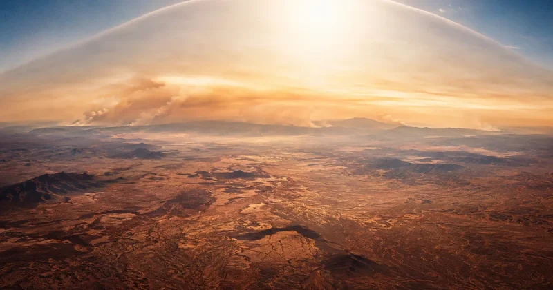 Aerial view of heat haze rising from desert landscape under an oppressive sky with wildfire smoke on the horizon