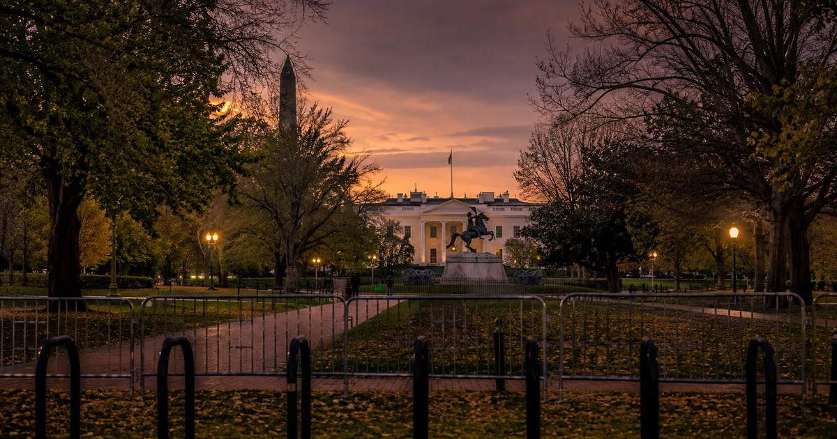 Lafayette Park in Washington DC at dusk with temporary metal barriers and the White House in the background