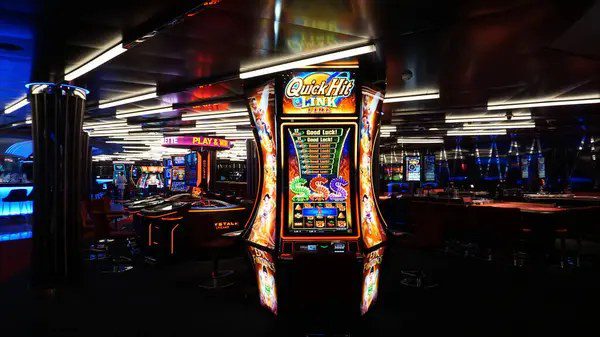 Row of illuminated slot machines on a casino floor