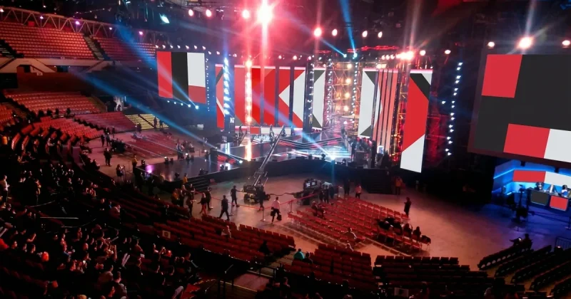Esports arena stage with LED screens, lighting rigs and a broadcast camera during a live tournament