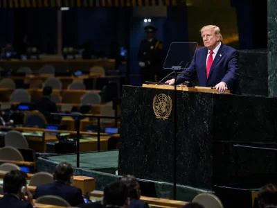 Donald Trump grips the green marble UN General Assembly rostrum while delegates sit in a half-empty hall