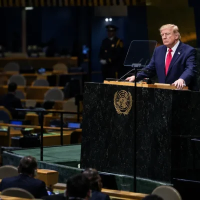 Donald Trump grips the green marble UN General Assembly rostrum while delegates sit in a half-empty hall