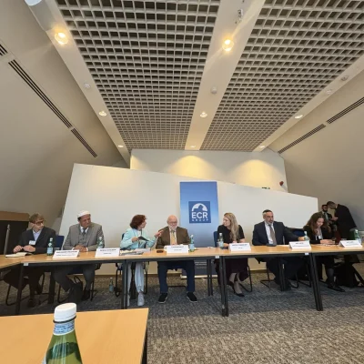 Participants seated at a long table during the roundtable on antisemitism at the European Parliament in Brussels