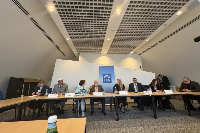 Participants seated at a long table during the roundtable on antisemitism at the European Parliament in Brussels