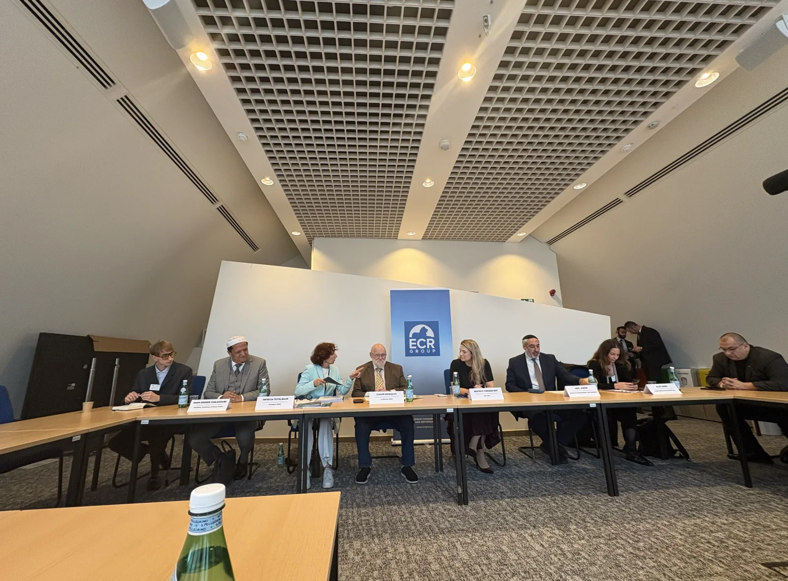 Participants seated at a long table during the roundtable on antisemitism at the European Parliament in Brussels