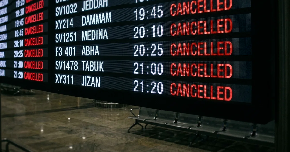 Illustration of an airport departures board in a darkened terminal with flights to Jeddah, Dammam, Medina, Abha, Tabuk and Jizan all marked cancelled in red