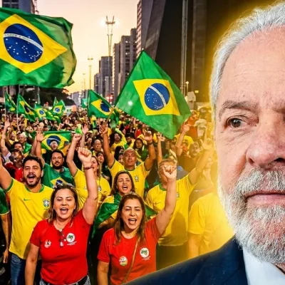 Brazilian President Luiz Inacio Lula da Silva in the foreground as a crowd of supporters in green, yellow and red wave Brazilian flags at a street rally.